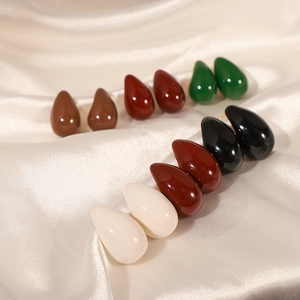 Enamel teardrop stud earrings in multiple colors on elegant beige satin fabric