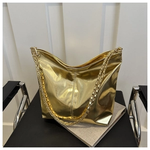Detail of a metallic gold hobo bag with gold chain strap on a black chair background