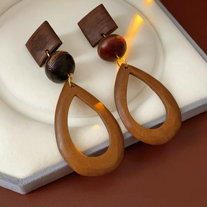 Detailed macro shot of vintage wooden teardrop earrings with golden metal links