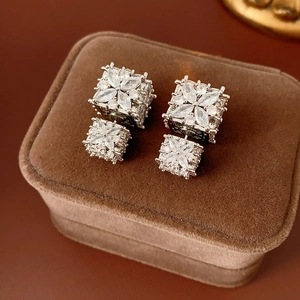 Gros plan sur des boucles d'oreilles en argent avec fleurs en zircon sur boîte en velours