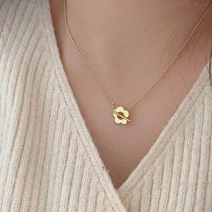 Close-up of a 925 silver flower pendant necklace on a model with a cozy knit sweater