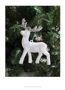 White flocked Christmas reindeer ornament with silver glitter antlers hanging on tree