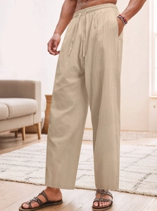Dettaglio dei pantaloni da spiaggia in lino beige con coulisse elastica e tasche laterali