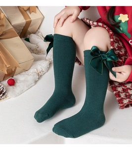 Gros plan de chaussettes hautes vert foncé pour filles avec détail de nœud en coton