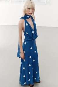 Détail d'une robe dos nu bleu foncé à pois avec écharpe assortie pour un style rétro