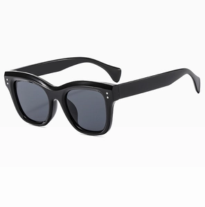 Detailed macro view of black square frame sunglasses with silver rivet accents