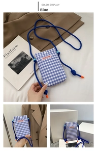 Detail of blue checkered mini crossbody phone bag with thick rope strap and orange accents
