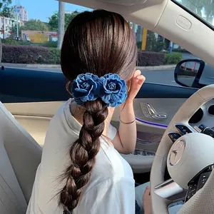 Vintage denim blue fabric flower hair clip styled on a braid in a car setting