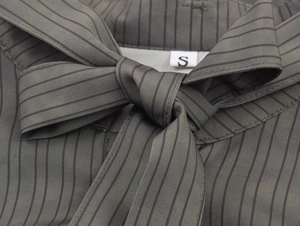 Detail of grey striped shirt fabric with elegant bow tie knot and size S label