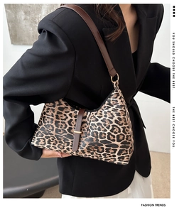Detailaufnahme der Umhängetasche mit Leopardenmuster, braunem Gurt und goldenen Beschlägen