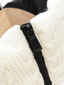 Close-up of white knitted fabric texture with premium black metal zipper detail