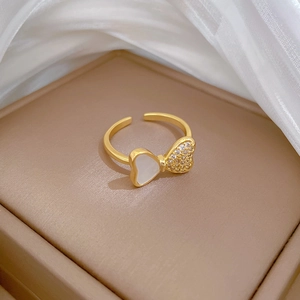 Detailaufnahme von Goldring mit Schmetterling, Muschelherz-Inlay und Kristallen
