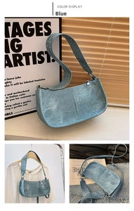 Detail of blue washed denim style shoulder bag with silver metallic eyelet studs