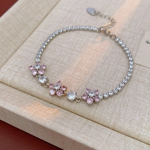 Close-up of silver cherry blossom tennis bracelet with pink and white zircon stones