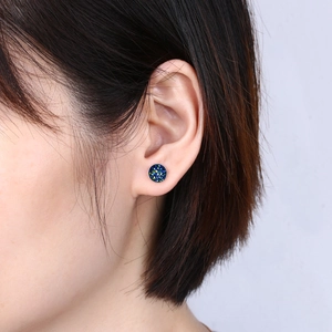Detailed close-up of a round S925 silver stud earring with blue and green crystal texture