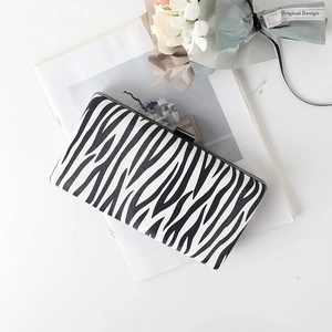 Macro shot of zebra pattern clutch with metallic frame texture and soft lighting