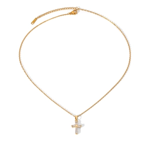 Close-up of gold-plated cross necklace pendant featuring sparkling crystal stones