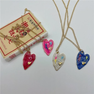 Colorful enamel heart pendant necklaces in red pink and blue with gold chain details