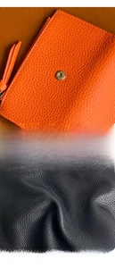 Detail of lychee pattern leather wallet with gold metal snap buttons in orange and black