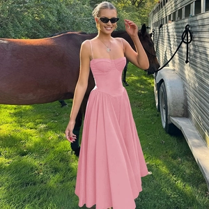 Detail of pink corset-style backless maxi dress in a sunny outdoor meadow setting