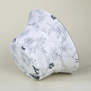Close-up of white bucket hat with hand-painted blue floral patterns and fine fabric texture