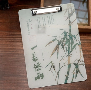 Detail of A4 acrylic clipboard with Chinese ink bamboo art and metal clip on wooden desk
