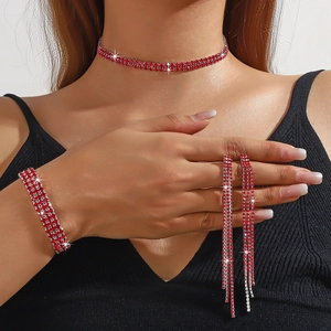 Detailed view of red rhinestone choker necklace, wide bracelet, and tassel earrings set