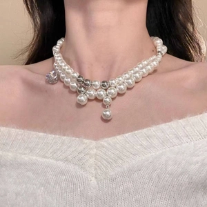 Elegant double-layer pearl necklace with silver accents on a woman wearing a white sweater
