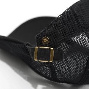 Close-up of black mesh fabric and adjustable vintage brass buckle on the hat