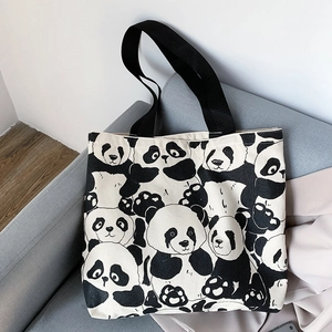 Detailed view of the double-sided panda print and sturdy black straps on the canvas tote