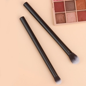 Detail view of dual black makeup brushes with white gradient bristles for eye blending