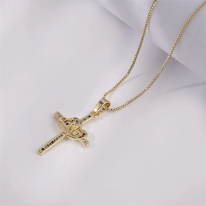 Dettaglio collana in oro con pendente a croce, doppio cuore e pietre preziose colorate
