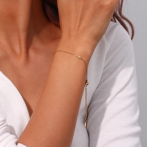 Detailed shot of 18K gold plated minimalist chain bracelet on a model's wrist