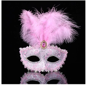 Close-up of pink lace masquerade mask with feathers, sequins and faux gemstone