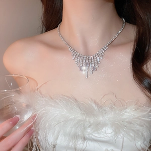 Macro shot of silver V-shaped tassel necklace with sparkling square zircon crystals