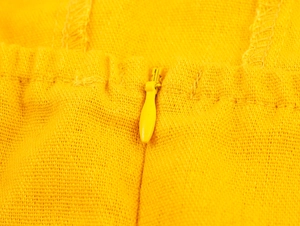 Detail of yellow off-shoulder dress with invisible zipper and premium woven texture