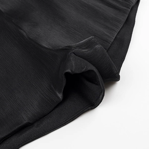 Close-up of black textured fabric with vertical silk-like grain and detailed stitching
