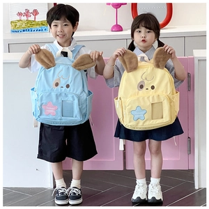 Detail of cute schoolbag with plush rabbit ears and star pattern in blue and yellow