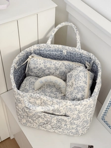 Close-up of quilted floral cotton storage baskets and embroidered Melody moon pillow