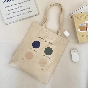 Detail of cream canvas tote bag featuring minimalist color palette print and artistic layout