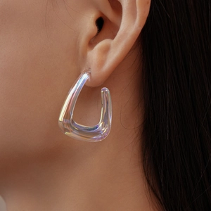 Close-up of chunky iridescent resin earrings with aurora finish on ear model