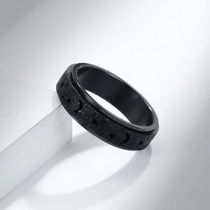 Vue détaillée d'une bague rotative noire avec motifs lune et étoiles sur surface mate