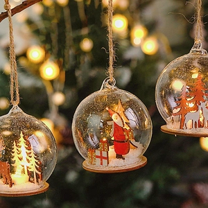 Close-up of glass Christmas ornament with Santa Claus miniature and warm glowing lights