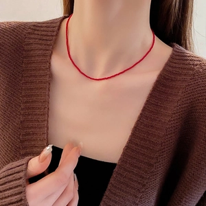 Vue rapprochée d'un collier minimaliste en perles de cristal rouge sur le cou