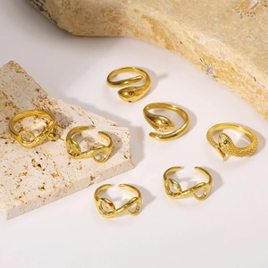 Classic gold plated snake rings with zircon accents on natural beige stones