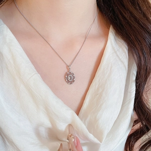 Macro view of oval cubic zirconia pendant necklace with light blue gemstone and silver chain