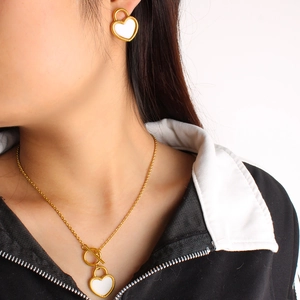 Gros plan d'un ensemble collier et boucles d'oreilles cadenas cœur doré sur mannequin
