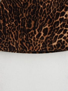Close-up of classic brown leopard print fabric texture with smooth soft finish