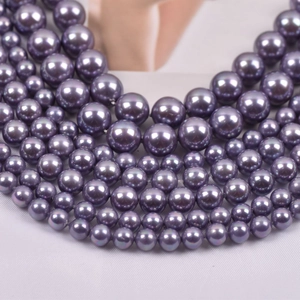 Macro detail of deep purple faux pearl beads with high-gloss finish for jewelry making