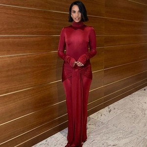 Détail d'une robe longue en velours rouge à col montant avec nœud à la taille élégant